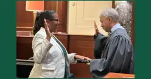 Mashea Ashton stands in front of a judge with one hand on a bible and the other in the air as she is sworn in as a Virginia Board of Education member.